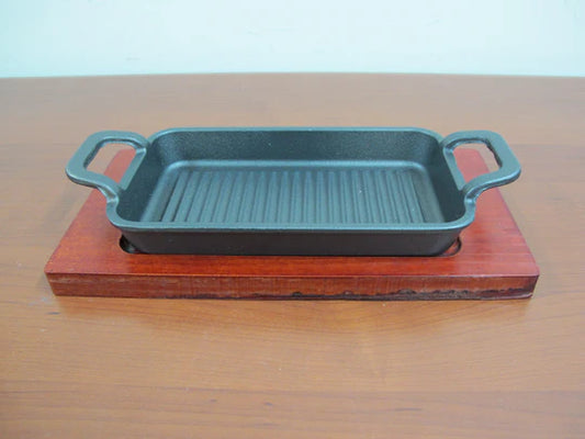 Large rectangular cast iron sizzling with wooden base